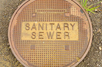 Manhole cover that says sanitary sewer